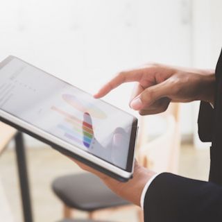 Cropped view of professional businessman working on his project with tablet in modern office room